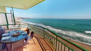 a balcony with a table and a view of the ocean at Olimpo II The Cruise - Front Line Beach in Fuengirola