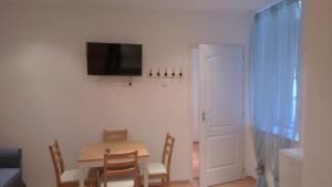 a dining room with a table and a television on the wall at Apartman 4 You Westend in Budapest