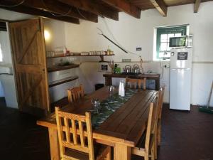 cocina con mesa de madera y nevera blanca en Klipfontein Rustic Farm & Camping, en Tulbagh