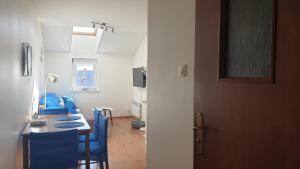 Habitación con mesa, sillas azules y puerta en Apartamenty Delfin, en Gdansk