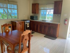 a kitchen with wooden cabinets and a wooden table and a table and a wooden table at POINCIANA APARTMENT ONE 257 POINCIANA DRIVE GREEN WOOD MONTEGO BAY JAMAICA in Montego Bay