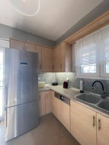 a kitchen with a stainless steel refrigerator and a sink at Seaside Deluxe Apartment in Skala Kallirachis