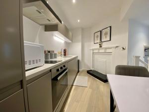 a kitchen with a counter and a stove top oven at Luxeurs - Victoria Street Apartments in Liverpool