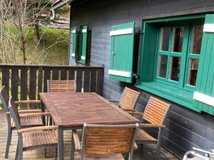 einen Holztisch und Stühle auf einer Terrasse in der Unterkunft Chalet Neunhoeffer by Interhome in Patergassen