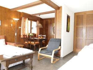 ein Wohnzimmer mit einem Stuhl und einem Tisch in der Unterkunft Apartment Pigne 1 by Interhome in Verbier
