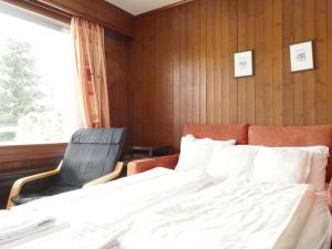 ein Schlafzimmer mit einem Bett, einem Stuhl und einem Fenster in der Unterkunft Apartment Pigne 1 by Interhome in Verbier