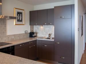 una cucina con armadi marroni e lavandino di Apartment Olympic R4 by Interhome a Nendaz