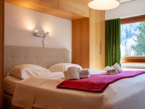 una camera da letto con un letto, asciugamani e una finestra di Apartment Olympic R4 by Interhome a Nendaz