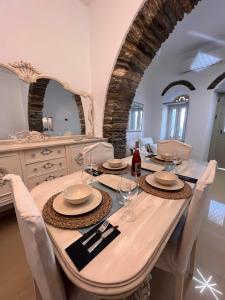 a dining room with a table with chairs and a mirror at Marianna's Studio in Tinos +5 photos