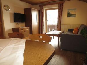 a living room with a bed and a couch and a table at Apartment Hof am Schönbach-1 by Interhome in Sankt Jakob
