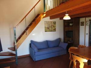 a living room with a blue couch and a staircase at Holiday Home Le Rose Rosse by Interhome in Grazzano Badoglio
