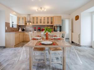 a kitchen with a large wooden table with chairs at Holiday Home Les Mésanges by Interhome in Canville-la-Rocque