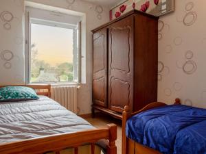 a bedroom with a bed and a dresser and a window at Holiday Home Les Mésanges by Interhome in Canville-la-Rocque