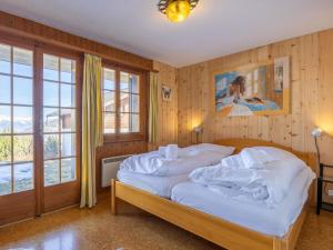 a bedroom with a bed with white sheets at Chalet L'Alouette by Interhome in Nendaz