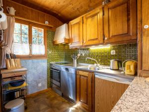 a kitchen with wooden cabinets and a stainless steel sink at Chalet L'Alouette by Interhome in Nendaz