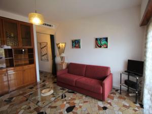 ein Wohnzimmer mit einem roten Sofa und einem Glastisch in der Unterkunft Studio Belmonte-4 by Interhome in Brezzo