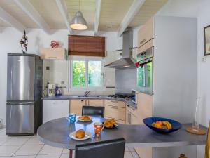 CléderにあるHoliday Home Le Triskell by Interhomeのキッチン(フルーツ付きのテーブル付)