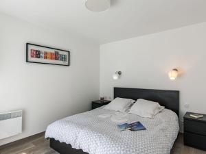 CléderにあるHoliday Home Le Triskell by Interhomeのベッドルーム1室(ベッド1台、本2冊付)