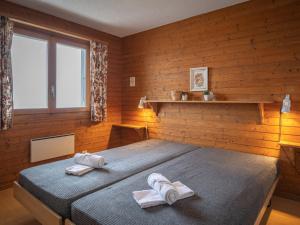 a bedroom with two beds with towels on them at Chalet Préplan by Interhome in Ovronnaz