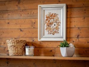 a wooden wall with a picture and a plant on a shelf at Chalet Préplan by Interhome in Ovronnaz