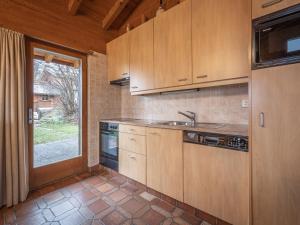 a kitchen with wooden cabinets and a sink and a window at Chalet Préplan by Interhome in Ovronnaz