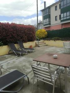 a patio with chairs and a table and a table and chairs at O Cruceiro in Palas de Rei