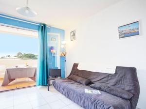 a living room with a couch and a table at Apartment Les Terrasses Fleuries by Interhome in Saint-Cyprien-Plage