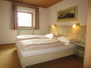a large white bed in a room with a window at Apartment Hof am Schönbach-2 by Interhome in Sankt Jakob