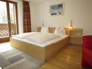 sypialnia z dużym łóżkiem z białymi poduszkami w obiekcie Apartment Schneider - STA251 by Interhome w mieście Sankt Anton am Arlberg