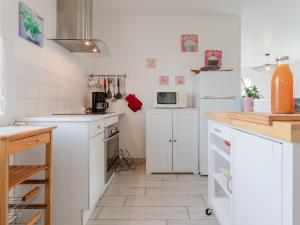 アヌヴィル・シュル・メールにあるHoliday Home Les Cordylines - ASM400 by Interhomeの白いキッチン(白いキャビネット、電化製品付)