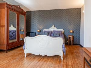 een slaapkamer met een wit bed en een houten vloer bij Holiday Home La Batterie - LON400 by Interhome in Longues-sur-Mer