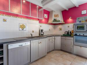 een keuken met witte kasten en roze muren bij Holiday Home La Batterie - LON400 by Interhome in Longues-sur-Mer