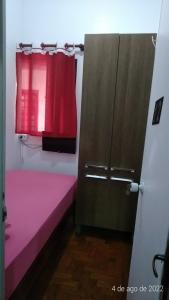 a room with a pink bed and a window at Quartos no centro de Itu - Hospedagem Elizabeth in Itu