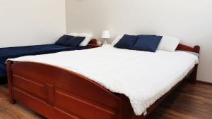 1 dormitorio con 2 camas y almohadas blancas y azules en Apartamenty Delfin, en Gdansk