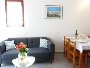 een woonkamer met een bank en een tafel bij Holiday Home Les Charmilles-6 by Interhome in La Palmyre