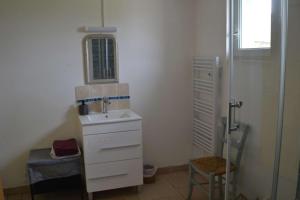 a white bathroom with a sink and a shower at accommodation à la ferme - appartement et mobilhome in Lubersac