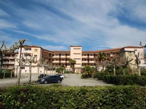 a building with a car parked in a parking lot at Apartment Belmonte-1 by Interhome in Brezzo