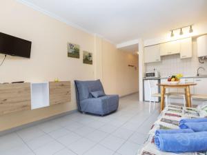 sala de estar con silla azul y cocina en Apartment Residencial Manureva-1 by Interhome, en L'Estartit