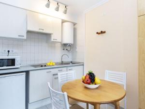 una cocina con una mesa con un bol de fruta. en Apartment Residencial Manureva-1 by Interhome, en L'Estartit