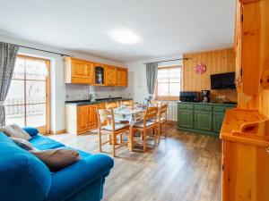 a living room with a blue couch and a table at Apartment Brunel-1 by Interhome in Pozza di Fassa