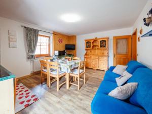 a living room with a blue couch and a table at Apartment Brunel-1 by Interhome in Pozza di Fassa