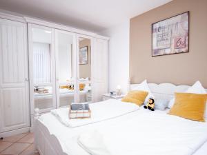 Apartment Seestern by Interhome في نورديش: غرفة نوم بسرير ابيض كبير مع مخدات صفراء