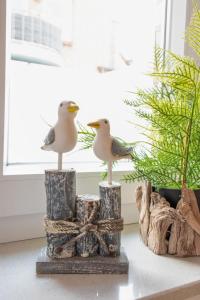 Apartment Seestern by Interhome في نورديش: اثنين من طيور النورس جالسين على قمة الحطب بجوار محطة