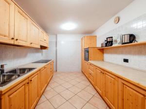a kitchen with wooden cabinets and a sink at Holiday Home Mantel by Interhome in Mazzin