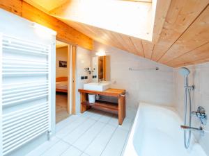 a bathroom with a tub and a sink in a room at Holiday Home Mantel by Interhome in Mazzin