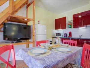 comedor con mesa con sillas y TV en Holiday Home Le Hameau du Rivage by Interhome, en Saint Cyprien Plage