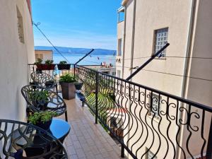 a balcony with benches and a view of the ocean at Black and White Apartment - 2 bedrooms, walk to the beach in Duće