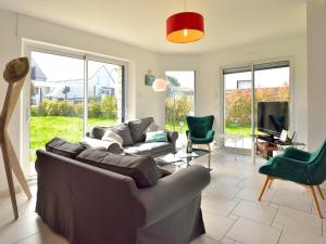 sala de estar con sofá, sillas y TV en Holiday Home Golf de Bretagne - RHU354 by Interhome, en Sarzeau
