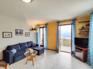 - un salon avec un canapé bleu et une fenêtre dans l'établissement Apartment La Trave - SZZ217 by Interhome, à Stazzona
