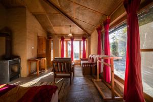 una stanza con tavolo e sedie in una casa di Binsar Forest Retreat a Binsar